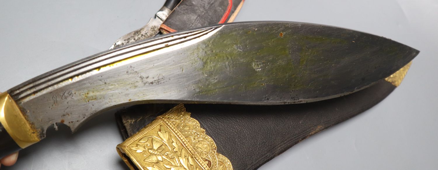 A kukri with skinning knives, leather sheath with elaborate embossed gilt metal mounts, blade 36cm